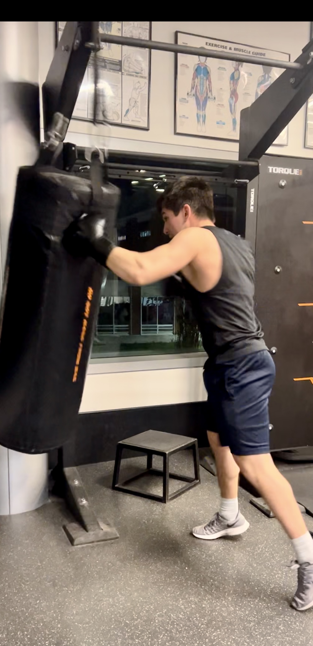 Instructor Matteo Buxo punching a punching bag at the gym